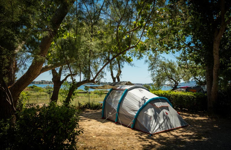 Emplacements à l'ombre pour tente au camping en bordure de l'étang de thau