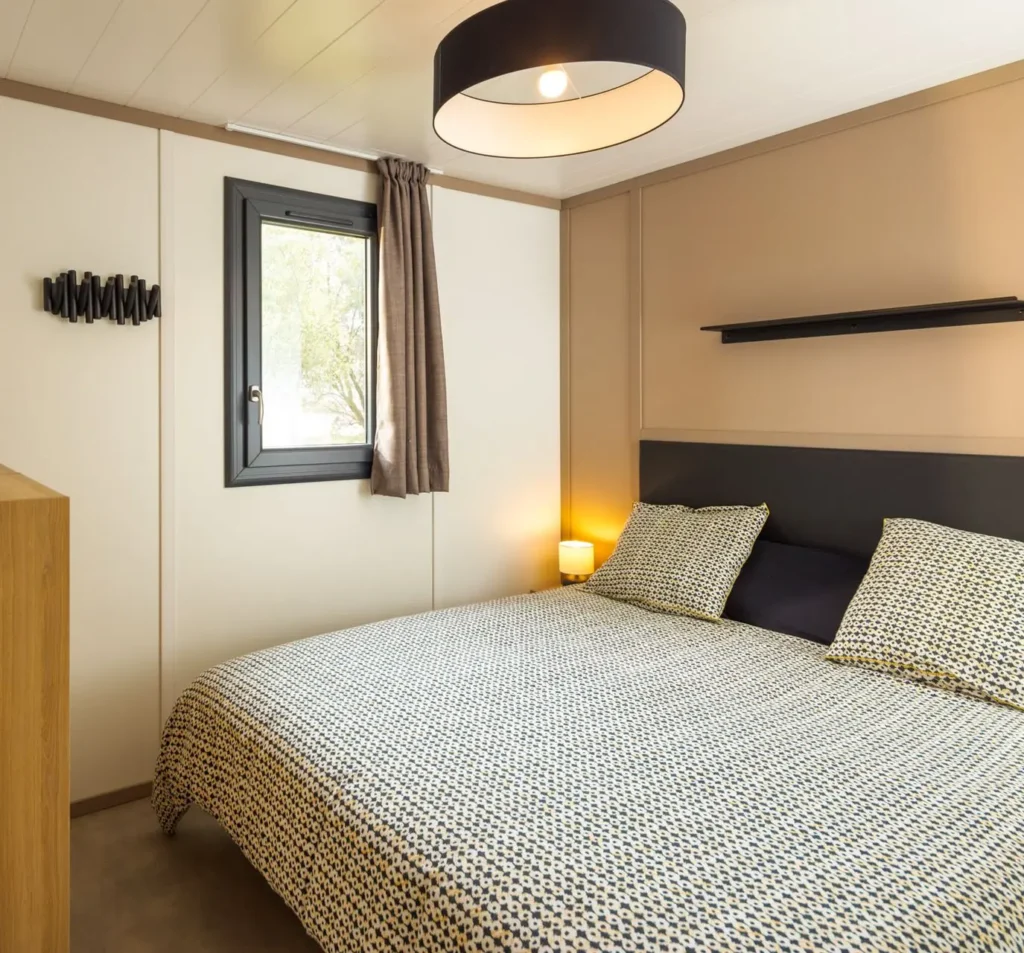 Chambre avec lit double du chalet Plus, en location au camping Lou Labech, camping 3 étoiles à Bouzigues dans l'Hérault