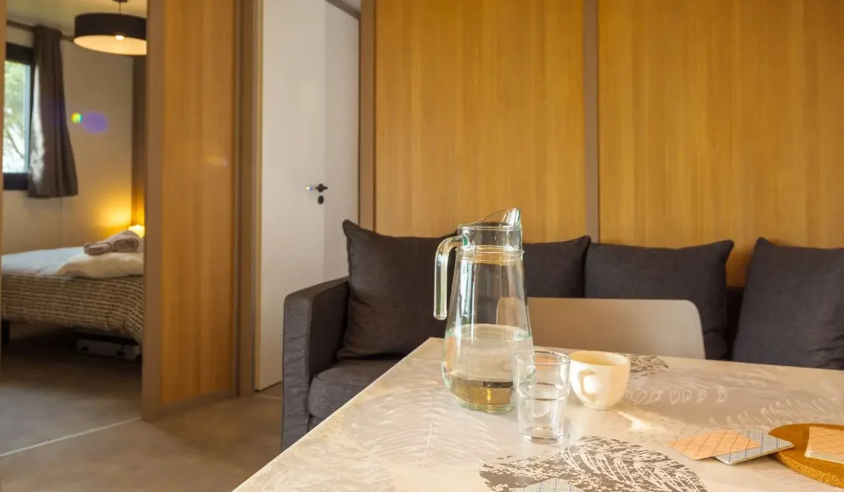 Coin repas et coin salon du chalet Plus, en location au camping Lou Labech, camping 3 étoiles à Bouzigues dans l'Hérault