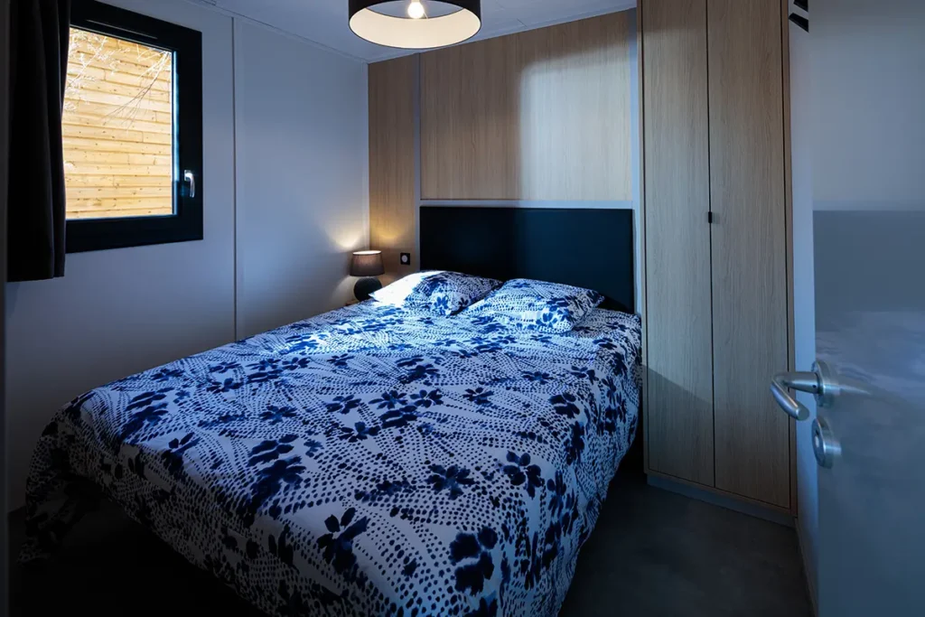 Chambre avec lit du chalet Casane, en location au camping Lou Labech, camping 3 étoiles à Bouzigues à proximité de l'étang de thau